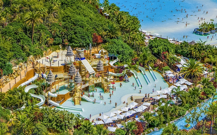 Aerial view of Siam Park's water slides and pools surrounded by lush greenery in Tenerife.