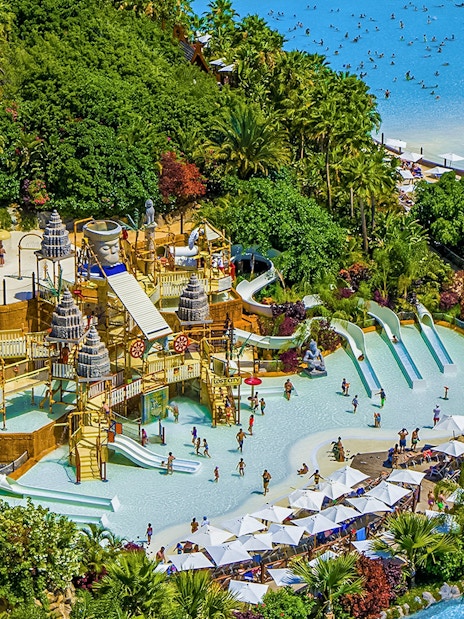 Aerial view of Siam Park's water slides and pools surrounded by lush greenery in Tenerife.