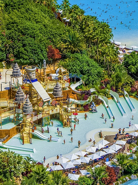 Aerial view of Siam Park's water slides and pools surrounded by lush greenery in Tenerife.
