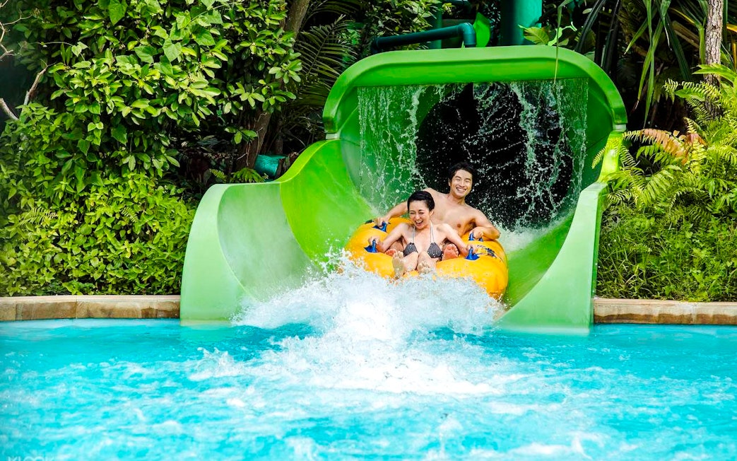 Visitors enjoying a water slide at Adventure Cove Waterpark, Singapore.
