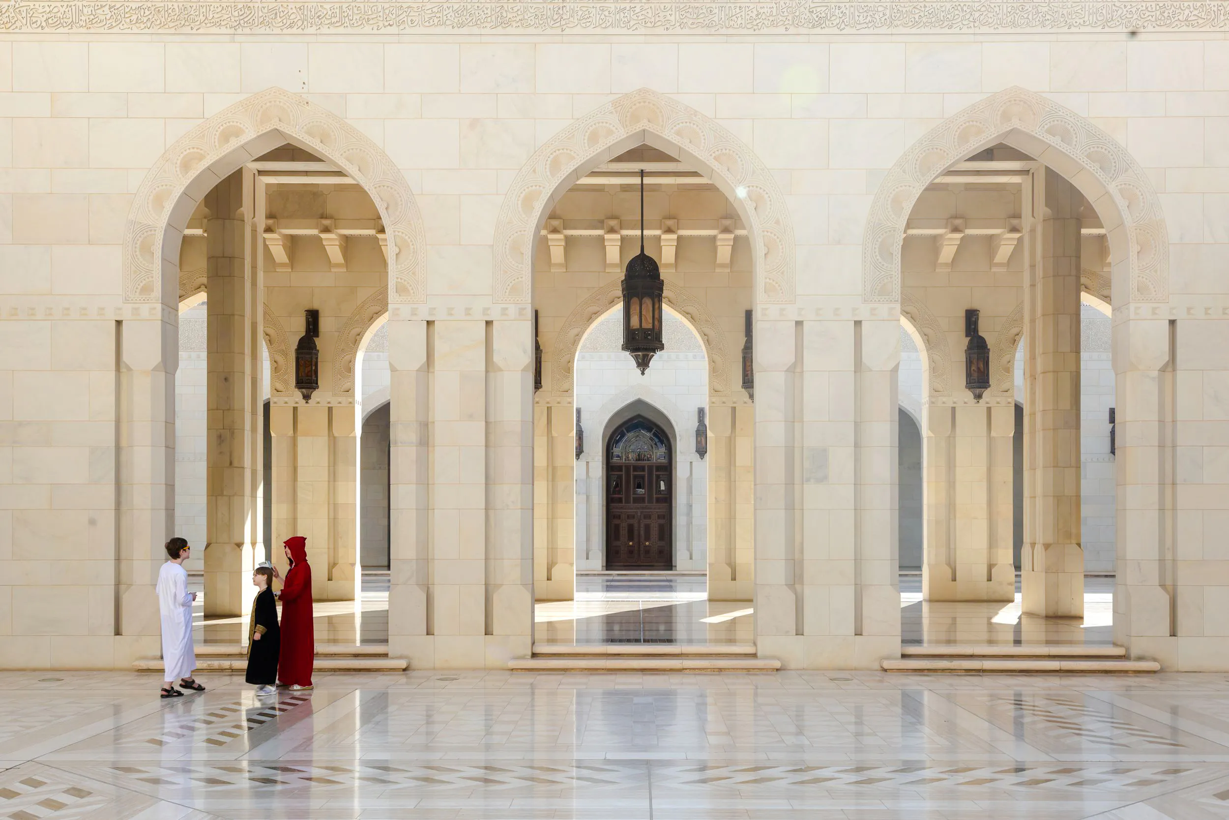 Grand Mosque arches with visitors, Muscat City Highlights Tour.