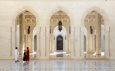Grand Mosque arches with visitors, Muscat City Highlights Tour.