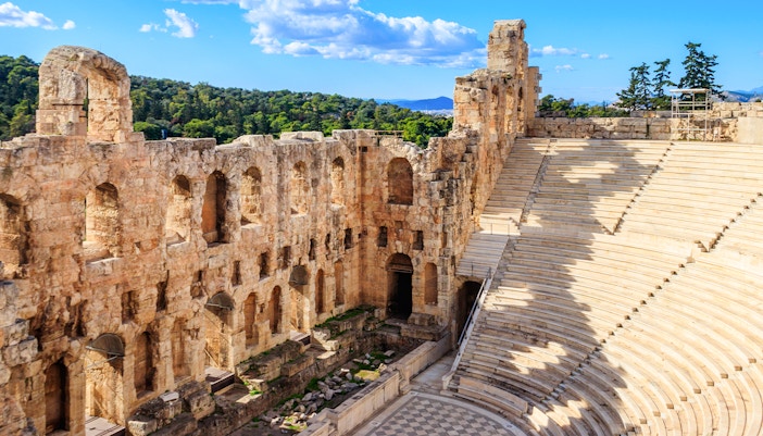 Odeon of Herodes Atticus in Athens with tourists exploring the ancient amphitheater.