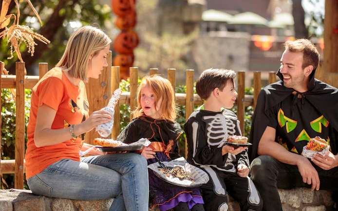 Family in Halloween costumes enjoying snacks at Canada's Wonderland, Six Flags.
