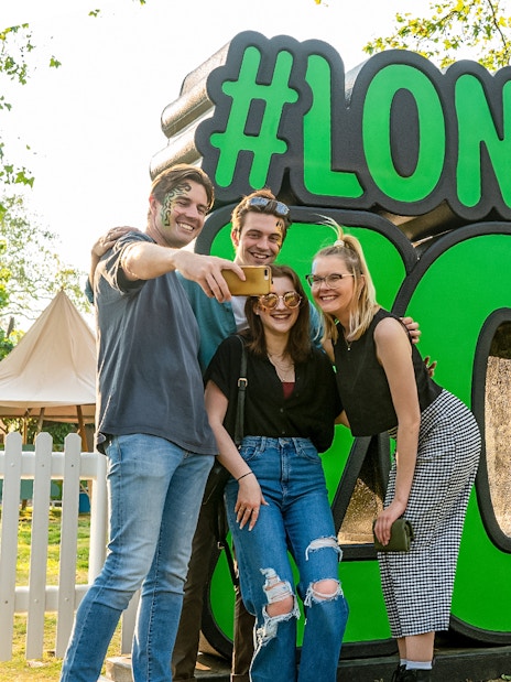 Group taking selfie in front of London Zoo sign.