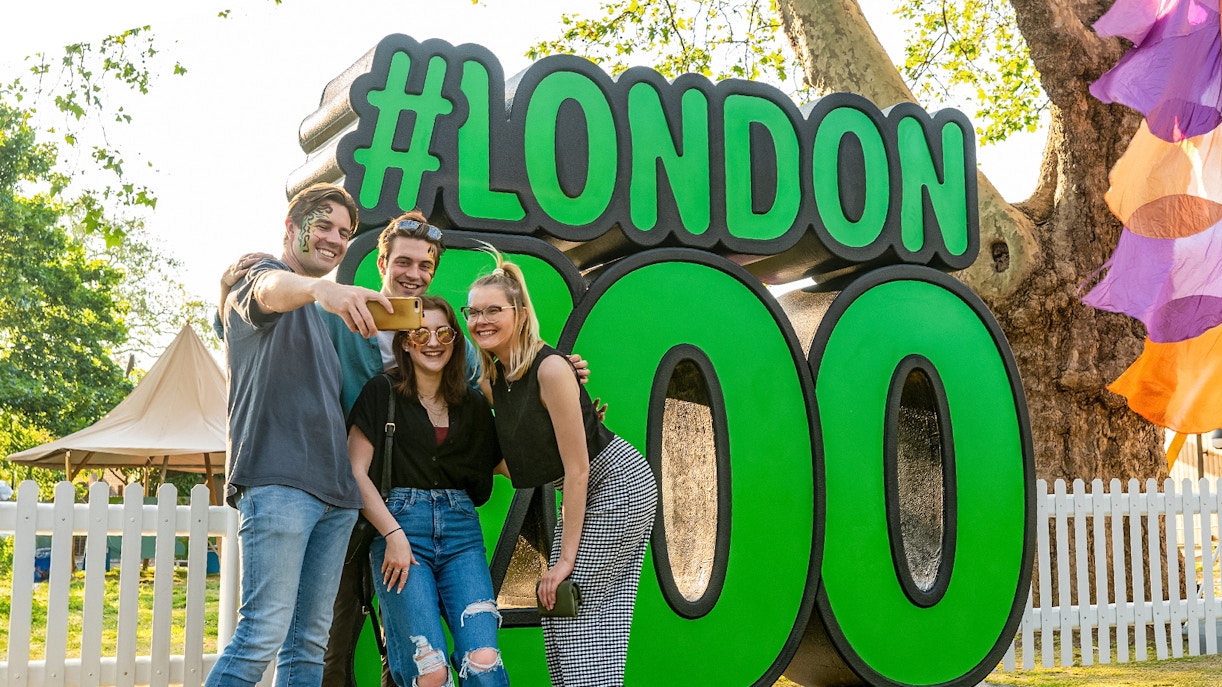 Group taking selfie in front of London Zoo sign.
