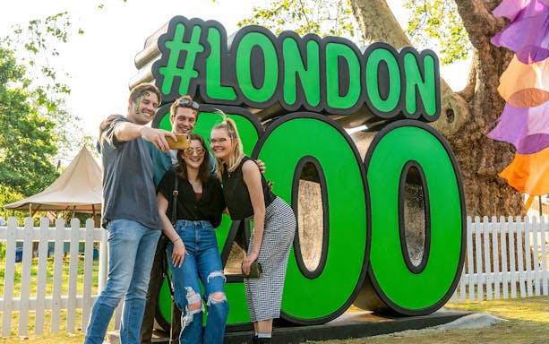 Group taking selfie in front of London Zoo sign.