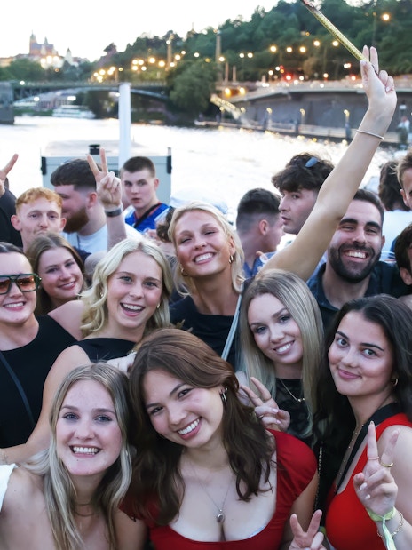 Group enjoying a boat cruise party on the Vltava River in Prague.