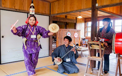Traditional performance at Ishigaki Yaima Village with musicians and dancer.