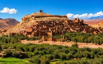 Aït Benhaddou ksar with clay buildings and lush greenery in Marrakech, Morocco.