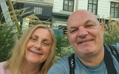 I don't know who these people are, but they are smiling in front of a Vienna street scene.