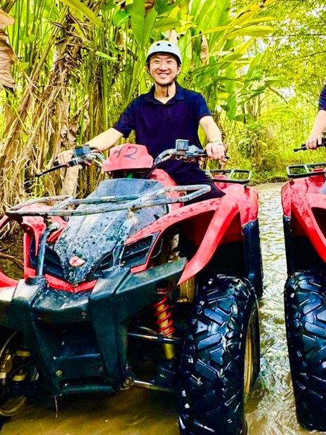 Couple riding ATVs through a forest trail during Mount Batur tour.