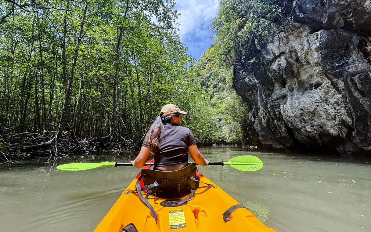 Tourist kayaking through Ao Thalane mangrove forest in Thailand.