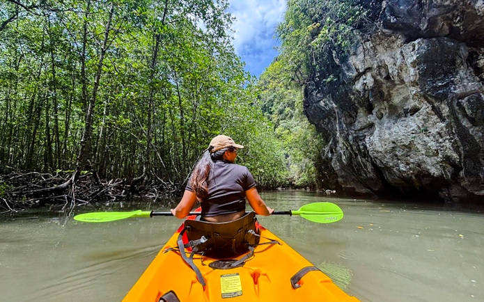 Tourist kayaking through Ao Thalane mangrove forest in Thailand.