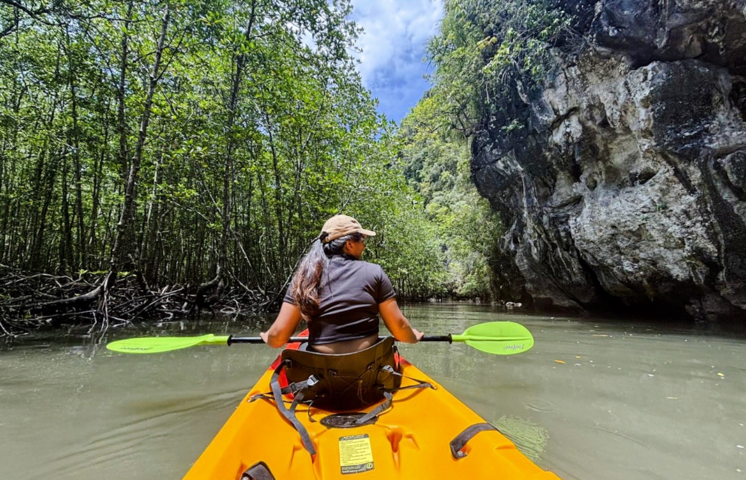 Tourist kayaking through Ao Thalane mangrove forest in Thailand.