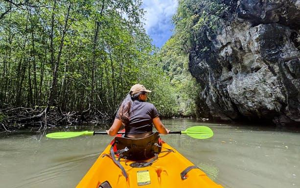Tourist kayaking through Ao Thalane mangrove forest in Thailand.