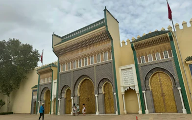 Royal Palace gate in Fes with intricate mosaic and golden doors.