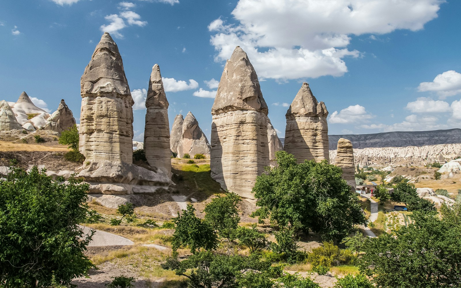 Fairy chimneys in Sword Valley, Cappadocia, Turkey, under a blue sky.