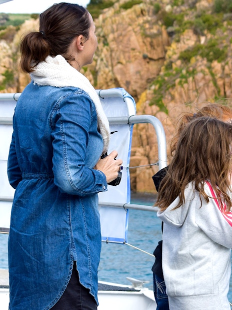 Visitors on a boat viewing Cape Woolamai's rocky coastline during a Phillip Island morning cruise.