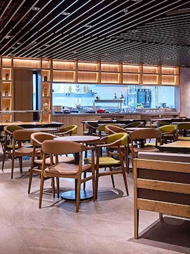 Seating area in Plaza Premium Lounge Kuala Lumpur with modern decor and dining tables.