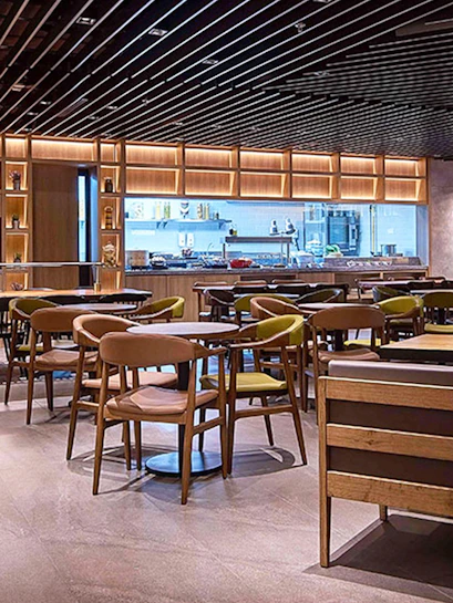 Seating area in Plaza Premium Lounge Kuala Lumpur with modern decor and dining tables.