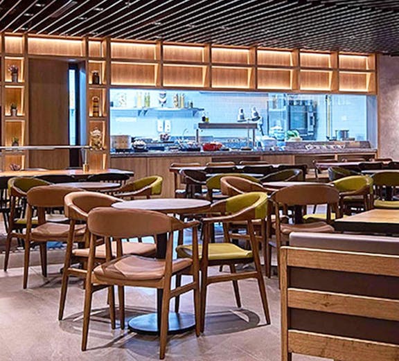 Seating area in Plaza Premium Lounge Kuala Lumpur with modern decor and dining tables.
