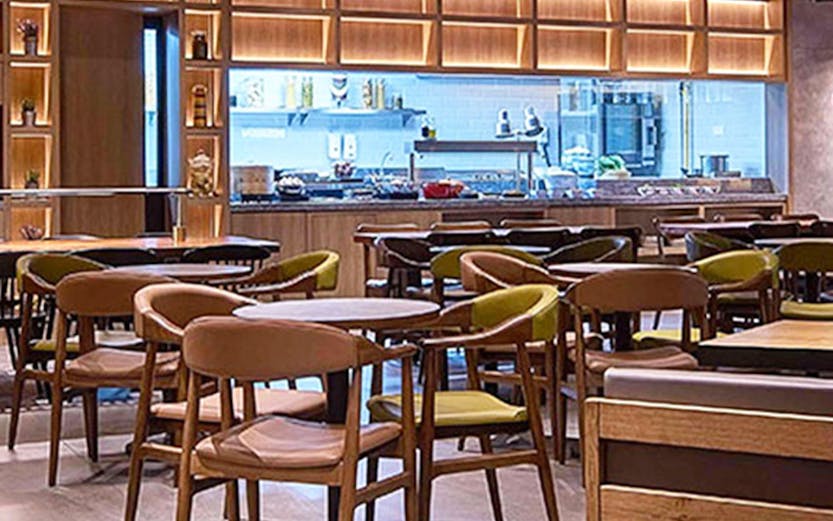 Seating area in Plaza Premium Lounge Kuala Lumpur with modern decor and dining tables.