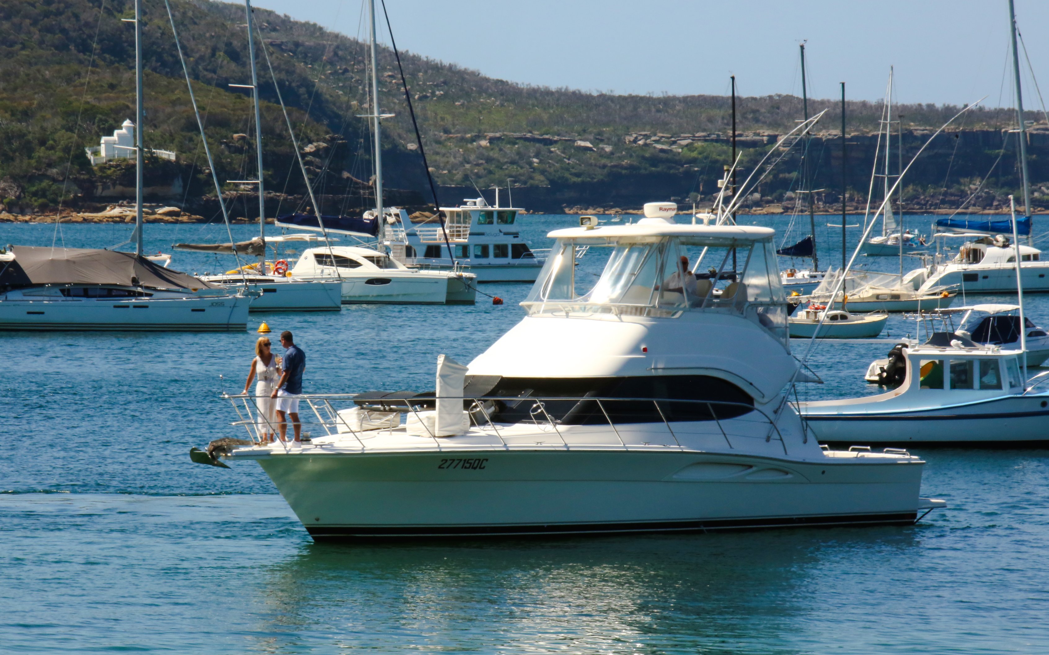 Sydney Harbour cruise boat with passengers enjoying the view, surrounded by yachts.