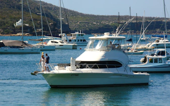 Sydney Harbour cruise boat with passengers enjoying the view, surrounded by yachts.