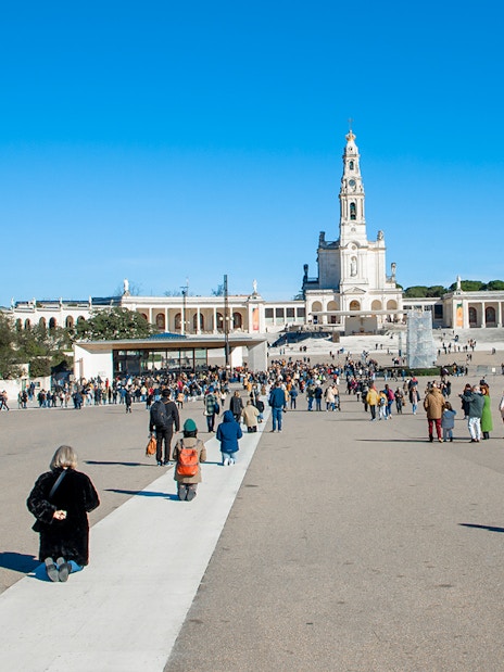 Visitors at the Square of the Basilica of Our Lady of Fatima, Portugal, seeking blessings.