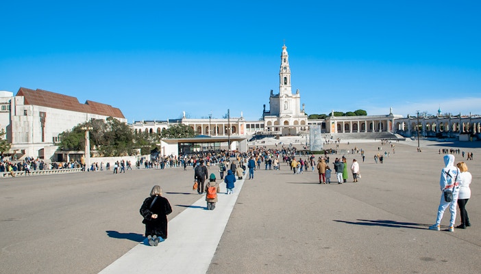 Visitors at the Square of the Basilica of Our Lady of Fatima, Portugal, seeking blessings.