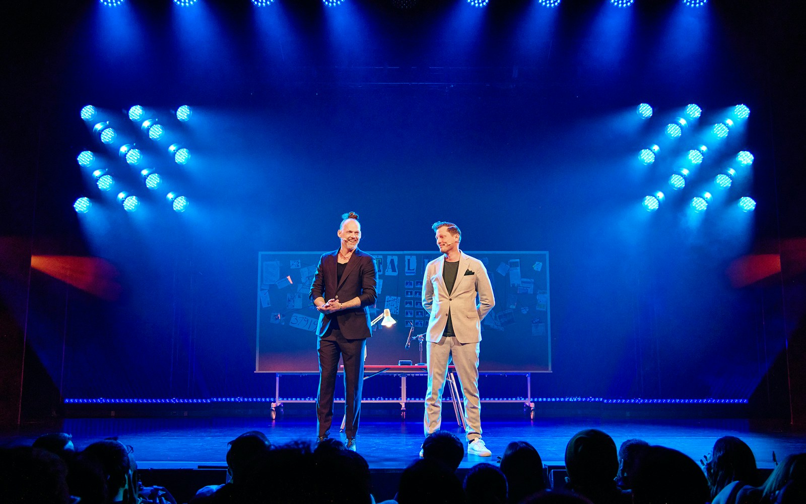 Two performers on stage with a board in the background during the Stalker show.