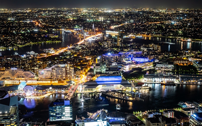 Night view of Sydney from Sydney Eye Tower, featuring illuminated cityscape and harbor.