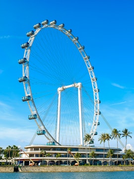 Ferris wheel at Singapore Flyer against blue sky.