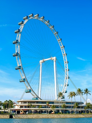 Ferris wheel at Singapore Flyer against blue sky.