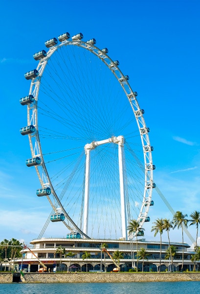 Ferris wheel at Singapore Flyer against blue sky.