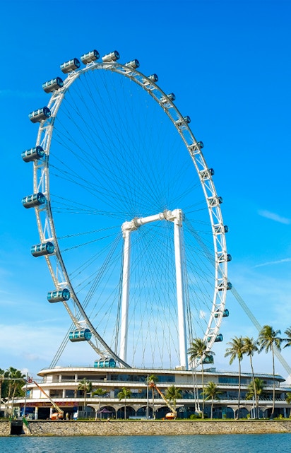 Ferris wheel at Singapore Flyer against blue sky.