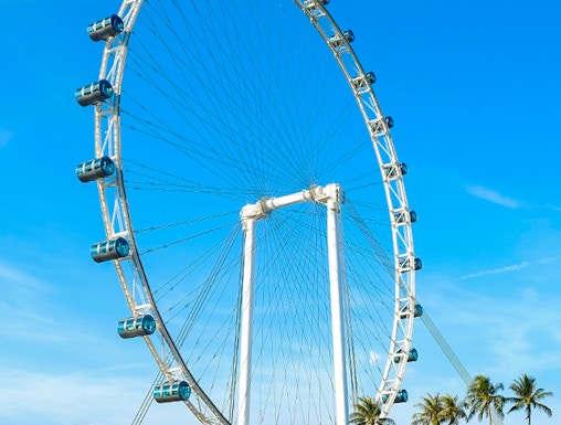 Ferris wheel at Singapore Flyer against blue sky.