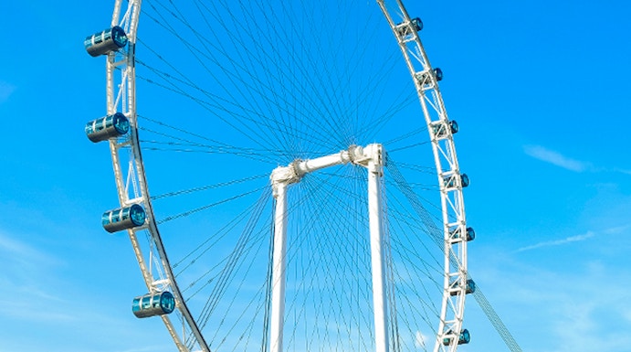 Ferris wheel at Singapore Flyer against blue sky.