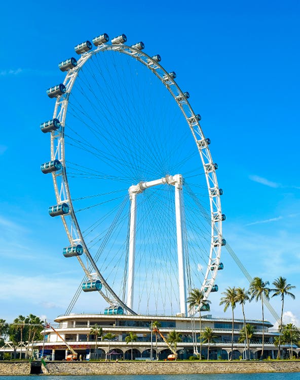 Ferris wheel at Singapore Flyer against blue sky.