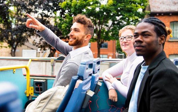 Tourists enjoying a ride on a double-decker bus in Dublin, part of City Sightseeing tour.