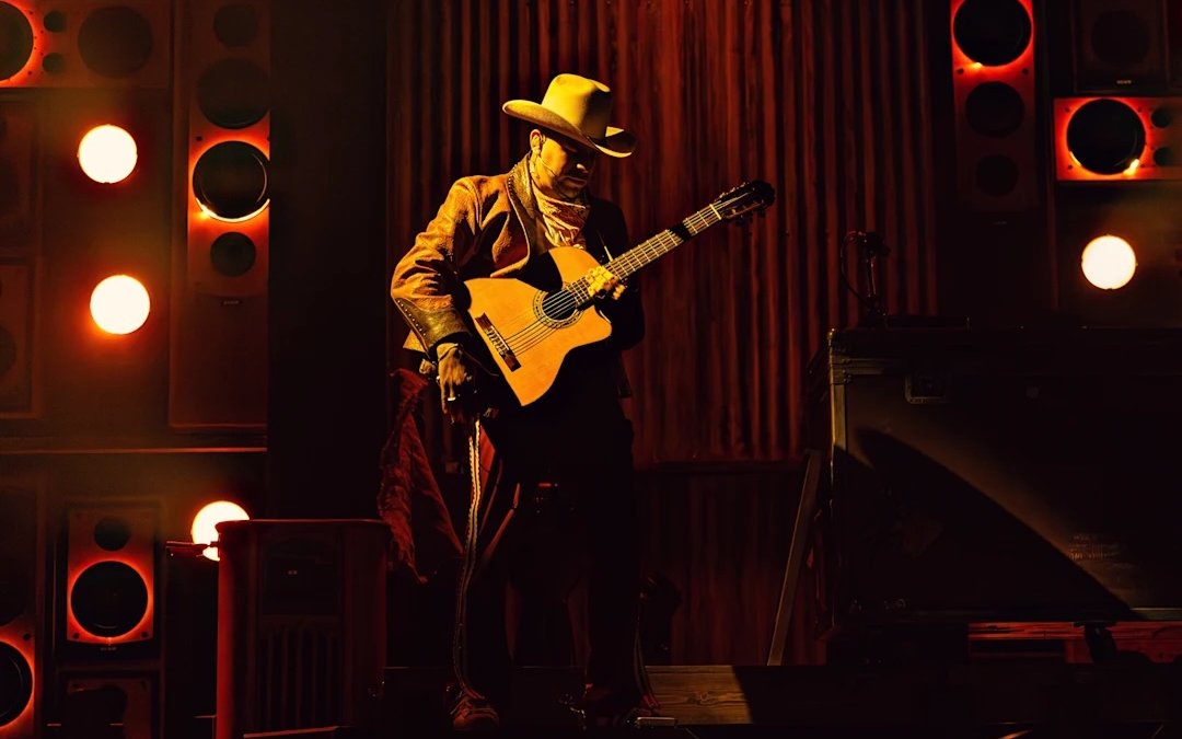 Performer with guitar on stage during Mexodus the Musical, Broadway.