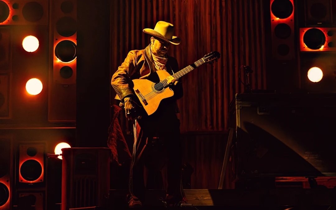 Performer with guitar on stage during Mexodus the Musical, Broadway.