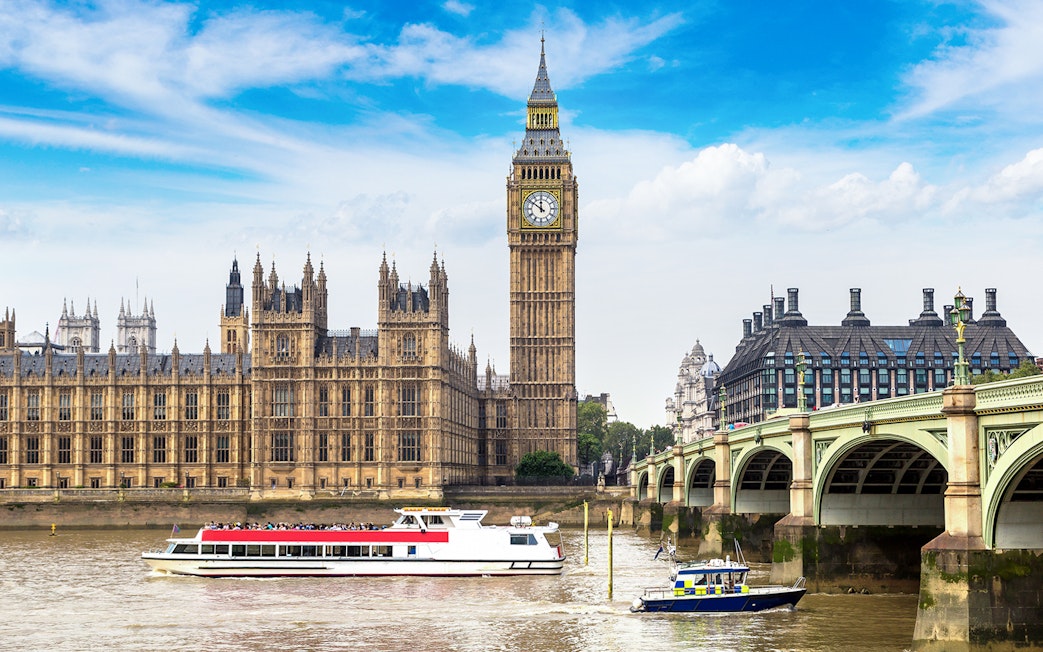 Cruise boat on the River Thames with Big Ben and Westminster Bridge, London.