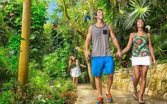 Couple walking through butterfly garden at Xcaret Park.