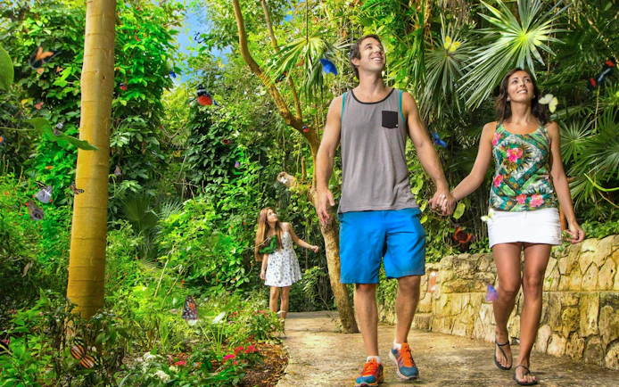 Couple walking through butterfly garden at Xcaret Park.