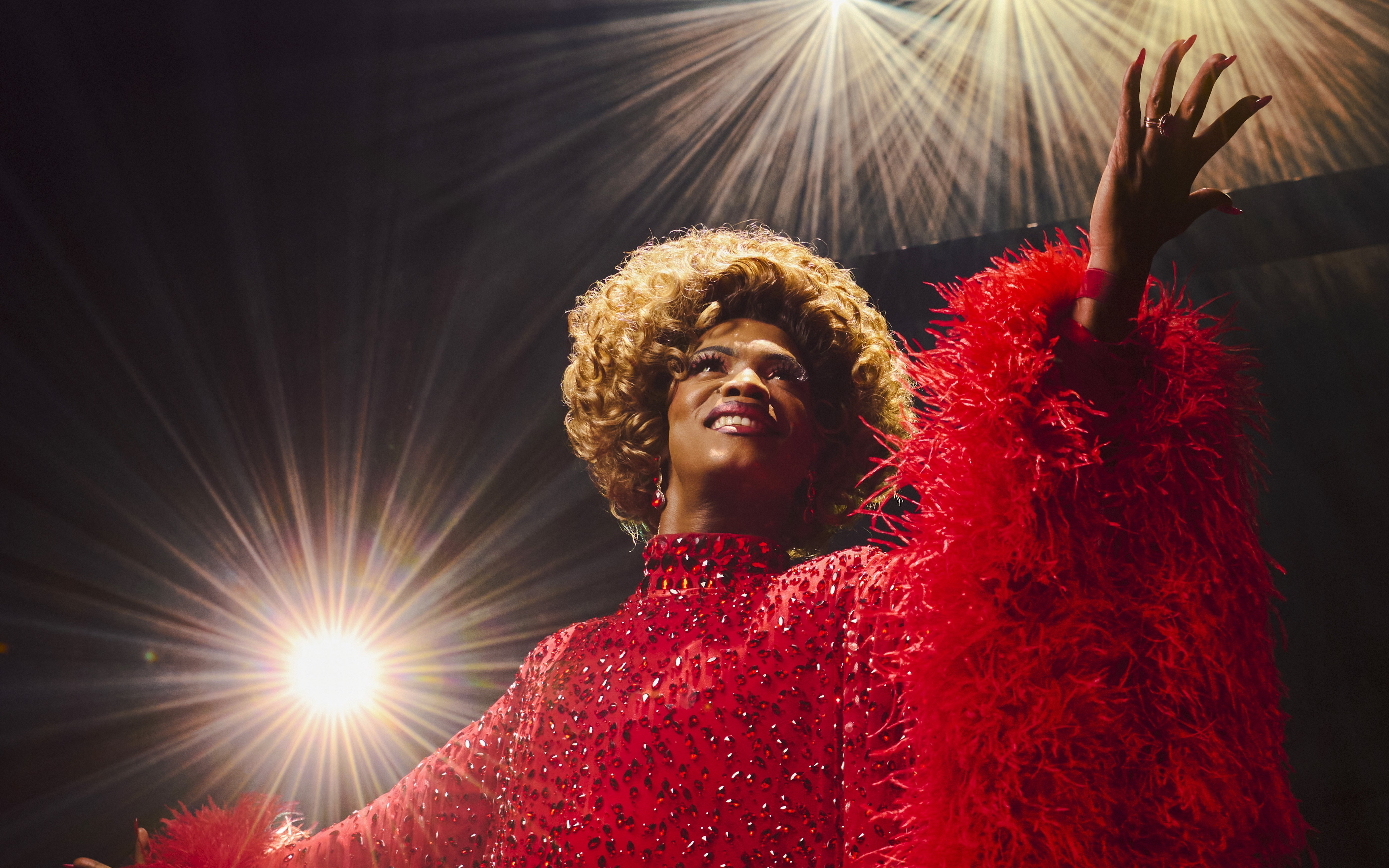 Performer in red costume on stage during Kinky Boots production.