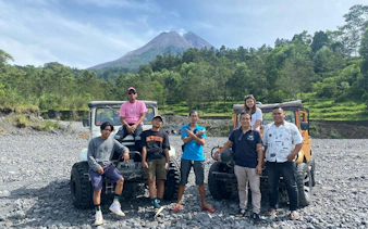Group posing with jeeps on rocky terrain during Sunrise Long Trip Lava Tour by JWM Adventure, Dubai.