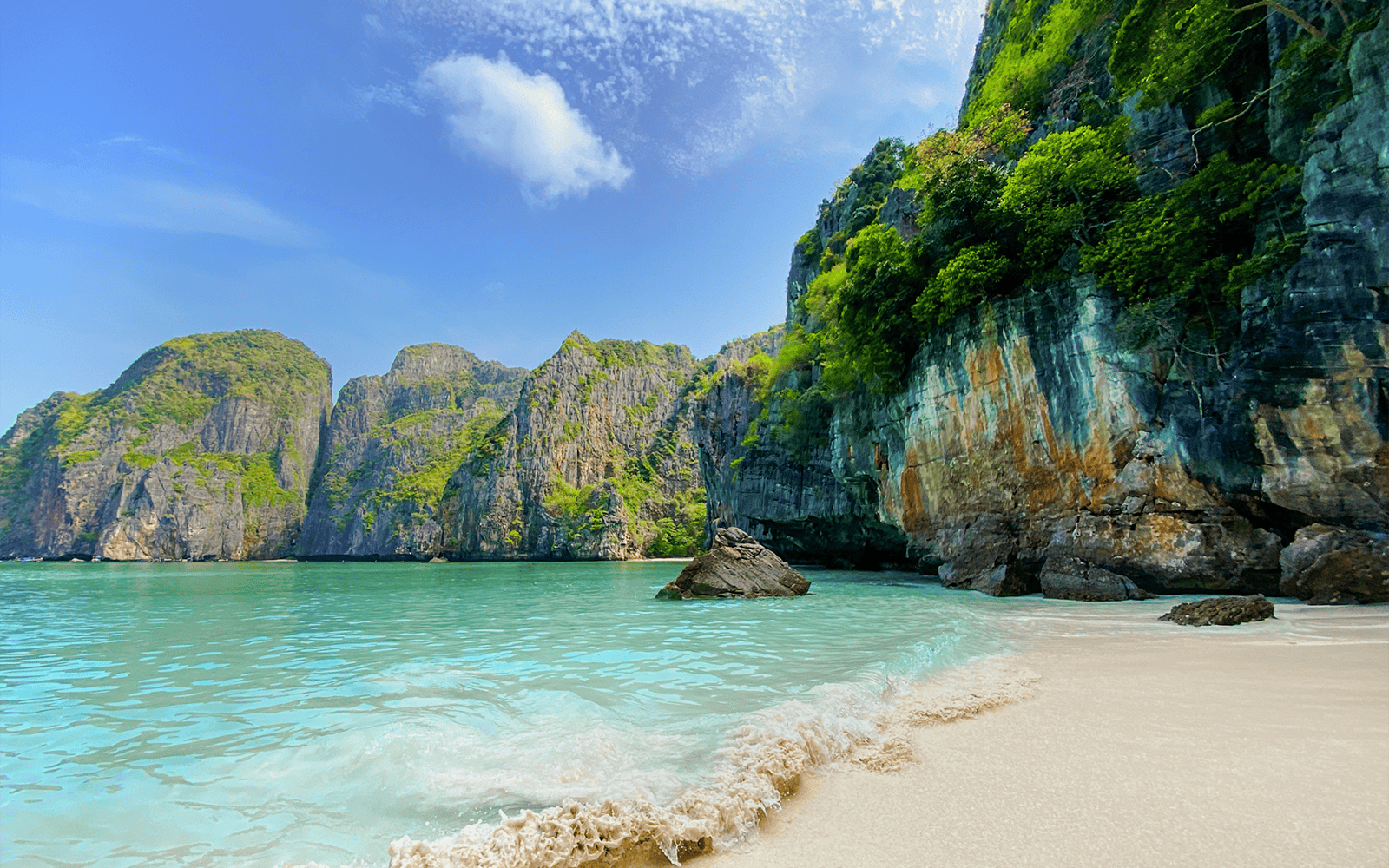 Beach with turquoise water and limestone cliffs at Maya Bay, Thailand.
