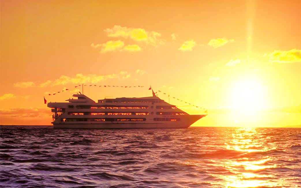 Star of Honolulu cruise ship sailing at sunset in Hawaii.